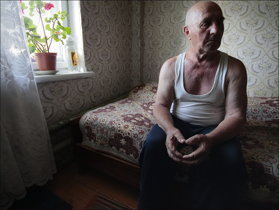 Пожилой мужчина у окна с геранью 