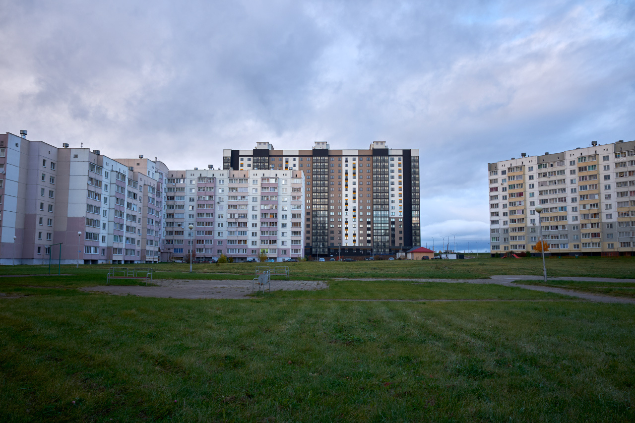 В новом районе здания двор трава небо облака