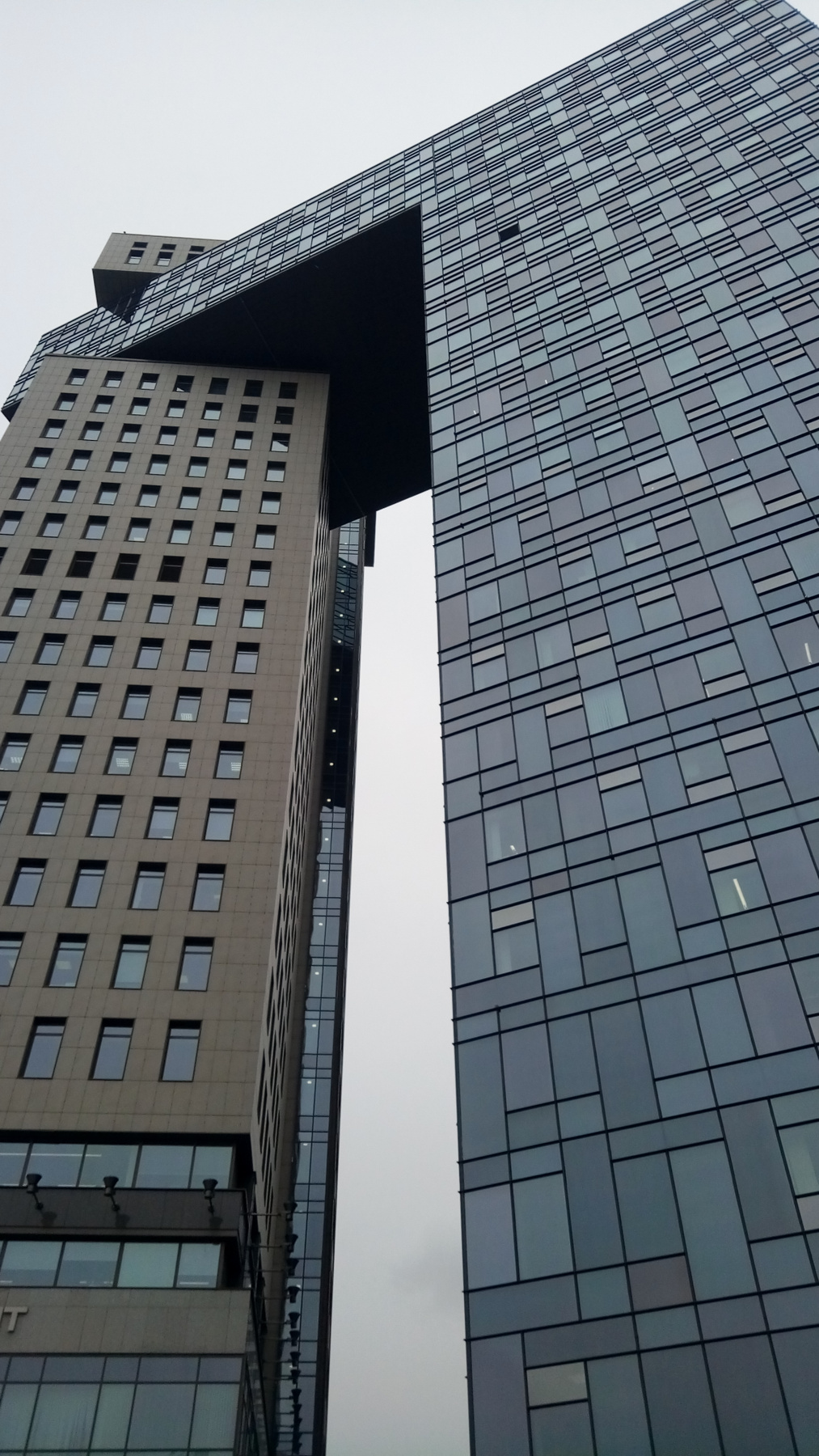 Нависающе... здание небоскреб оригинальная архитектура пасмурно
