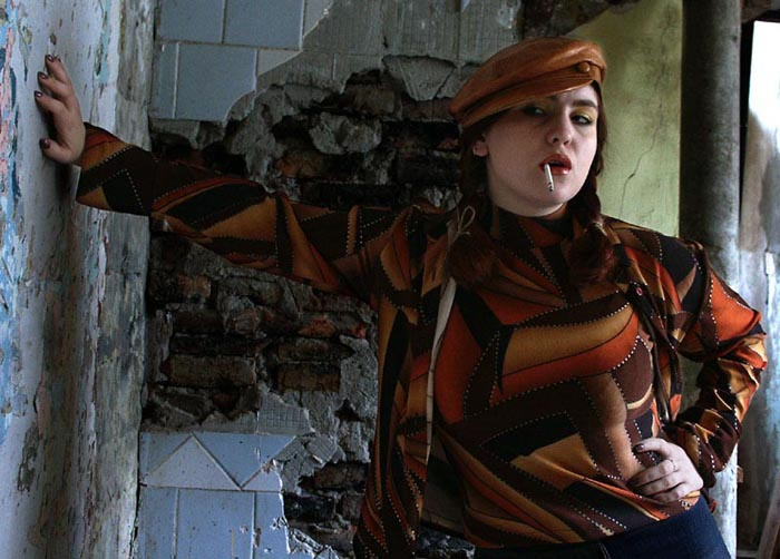 ...Мы Подошли Из За Угла... портрет девушки в кепке с папиросой пафосного нагловатого вида на фоне разрушеных обшарпаных кирпичных стен...