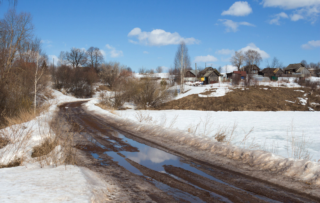 В весеннюю деревню Дорога колея снег вода отражения деревня склон деревья облака весна