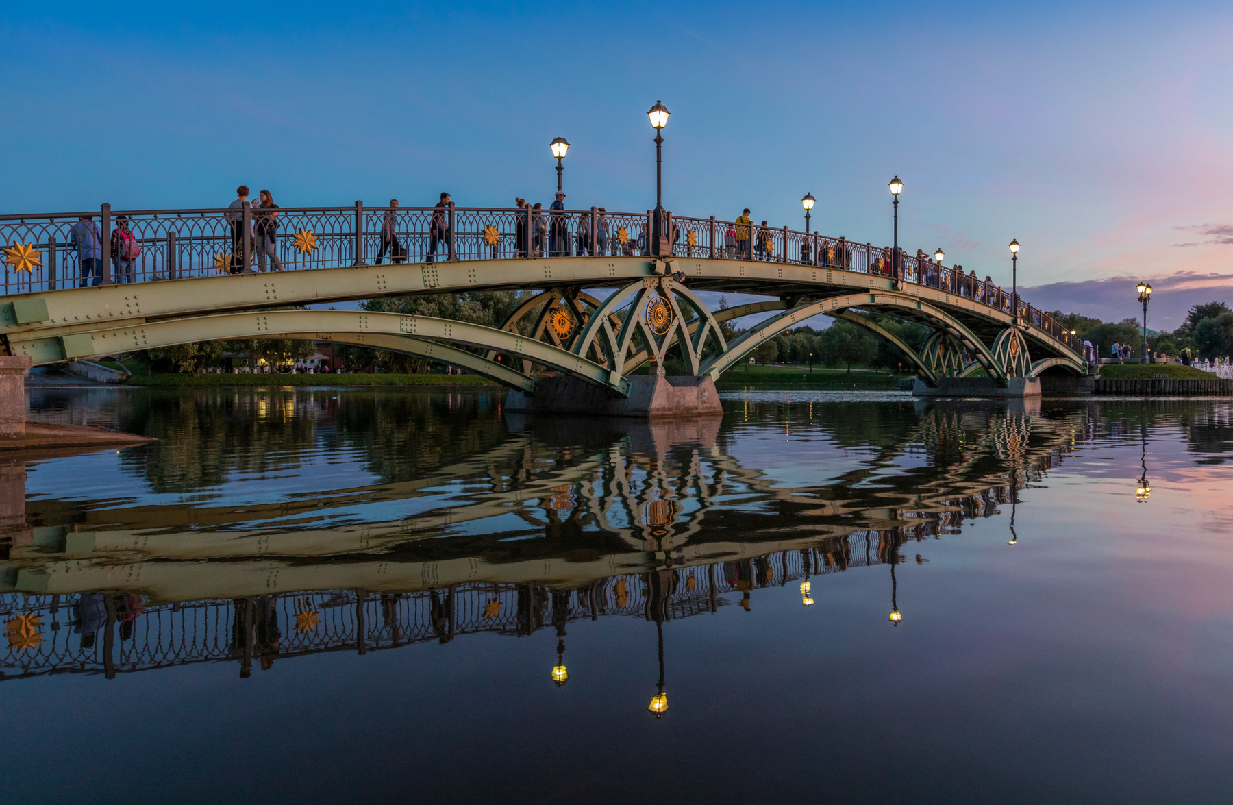 «Вечер, разделённый водой» мост вечер синий час отражение вода фонари архитектура городской пейзаж парк прогулка закат сумерки спокойствие симметрия река