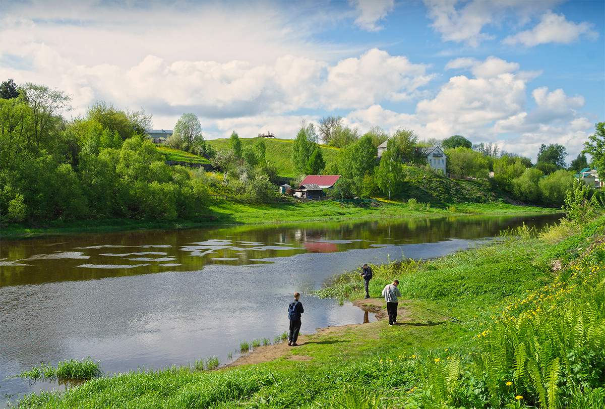На берегу реки река весна рыбаки постройки провинция вода небо берег трава облака