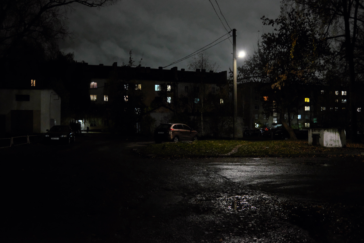 Октябрьский вечер 14 вечер двор фонарь здания окна деревья небо облака автомобили лужи